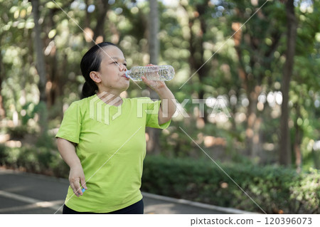 Woman Jogging in a Lush Garden Setting, Embracing Fitness and Nature in a Serene Outdoor Environment 120396073