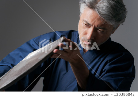 Image of a male potter holding a plate 120396842