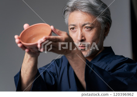 Image of a male potter holding a tea bowl Image of a male potter holding a tea bowl 120396962