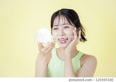 Summer image Yellow background Young woman looking in the mirror Summer image Yellow background Young woman looking in the mirror 120397280