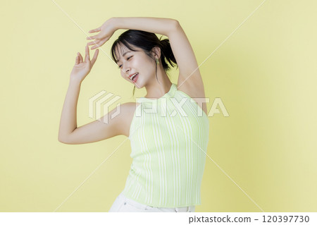 Summer image, yellow background, portrait of a young woman wearing a tank top 120397730