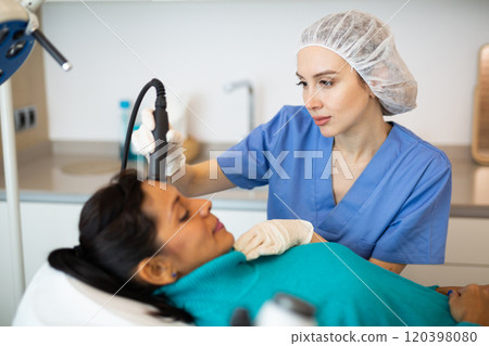 Woman receiving face ultrasound lifting procedure 120398080