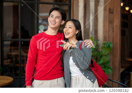 A sweet, happy Asian couple in cozy clothes enjoy strolling through the city on the weekend. A sweet, happy Asian couple in cozy clothes enjoy strolling through the city on the weekend. 120398182