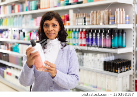 Woman choosing hair shampoo in cosmetics store 120398197
