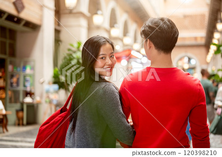 A beautiful young Asian woman enjoys shopping with her boyfriend at a mall on Christmas. A beautiful young Asian woman enjoys shopping with her boyfriend at a mall on Christmas. 120398210