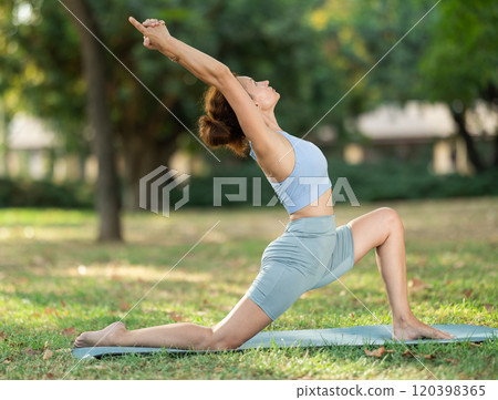 Adult woman doing stretching in park 120398365