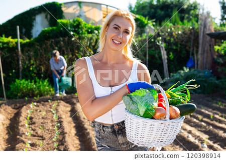 Cheerful girl with fresh vegetable harvest in backyard garden Cheerful girl with fresh vegetable harvest in backyard garden 120398914