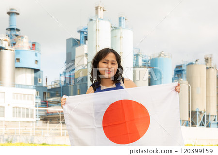 Happy young woman with flag of Japan against background of factory Happy young woman with flag of Japan against background of factory 120399159
