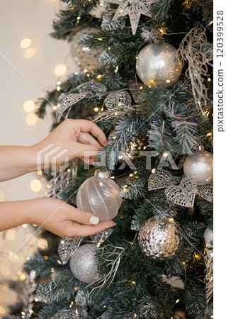 Woman decorating Christmas tree at home, closeup Woman decorating Christmas tree at home, closeup 120399528