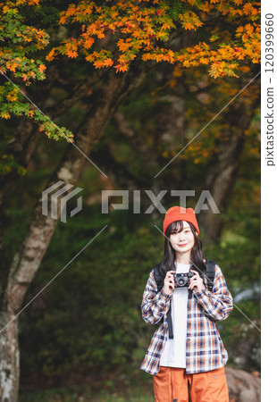 Woman climbing a mountain with a camera Woman climbing a mountain with a camera 120399660