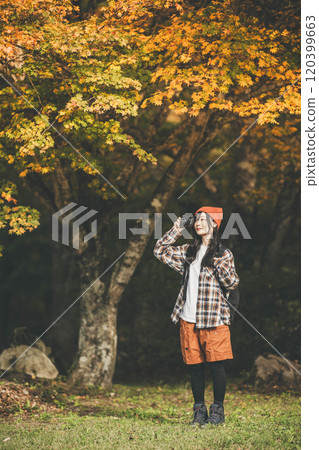 Woman climbing a mountain with a camera 120399663