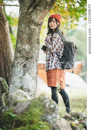 Woman climbing a mountain with a camera Woman climbing a mountain with a camera 120399674