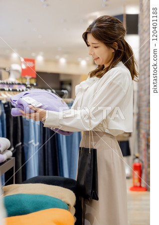 Woman enjoying shopping at an apparel store Woman enjoying shopping at an apparel store 120401188