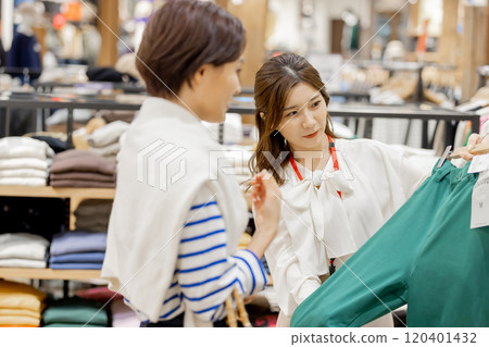 Apparel clerk recommending new clothes 120401432