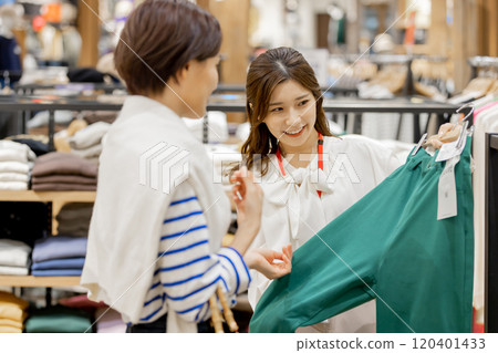 Apparel clerk recommending new clothes 120401433