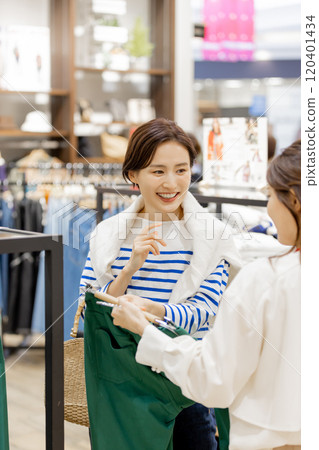 Apparel clerk recommending new clothes 120401434