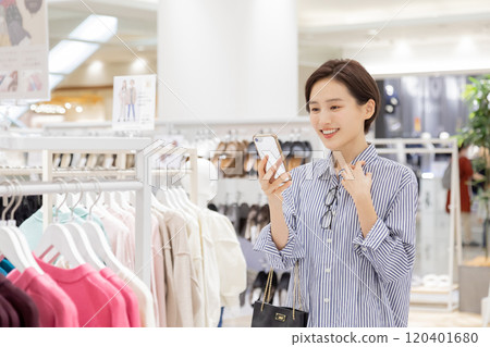 Woman enjoying shopping in a boutique Woman enjoying shopping in a boutique 120401680