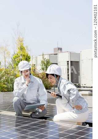 Businessmen and female workers checking solar panels Businessmen and female workers checking solar panels 120402101