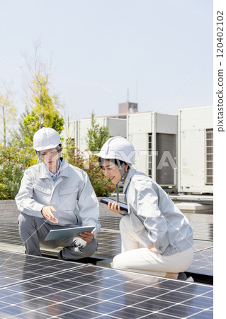Businessmen and female workers checking solar panels Businessmen and female workers checking solar panels 120402102