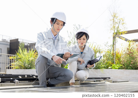 Workers checking solar panels 120402155