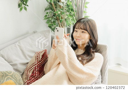 Woman relaxing on the sofa Woman relaxing on the sofa 120402372
