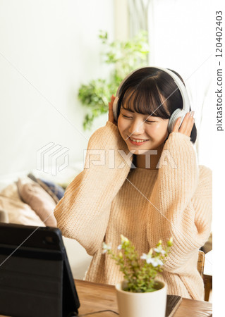 College students enjoying videos and music on tablets 120402403