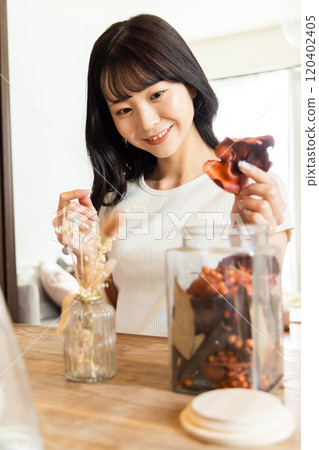 乾花一個年輕女人享受插花 乾花一個年輕女人享受插花 120402405