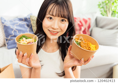 使用午餐外賣和送貨上門的年輕女性 使用午餐外賣和送貨上門的年輕女性 120402413