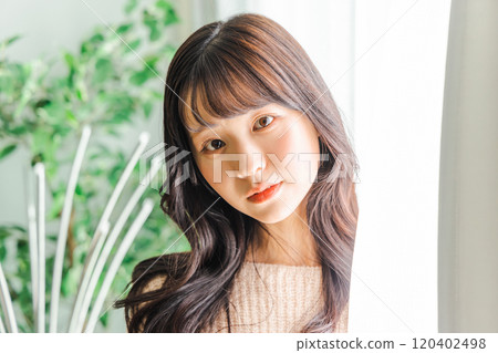 Knitted woman standing by the window 120402498