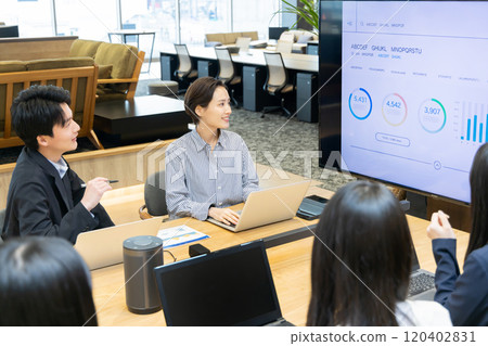 Men and women having a meeting using a monitor Men and women having a meeting using a monitor 120402831