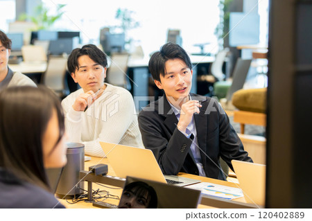 Men and women having a meeting using a monitor Men and women having a meeting using a monitor 120402889