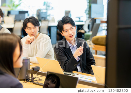 Men and women having a meeting using a monitor Men and women having a meeting using a monitor 120402890