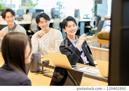 Men and women having a meeting using a monitor Men and women having a meeting using a monitor 120402892