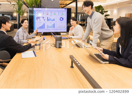 Men and women having a meeting using a monitor Men and women having a meeting using a monitor 120402899