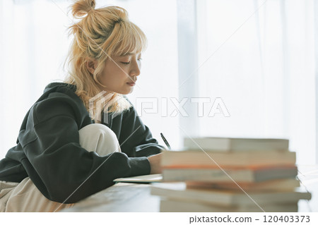 A young blonde woman studying towards her dreams 120403373
