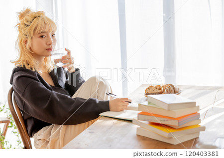 一位年輕的金髮女郎正在為她的夢想而學習 120403381