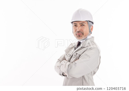 A man in work clothes with his arms crossed 120403716