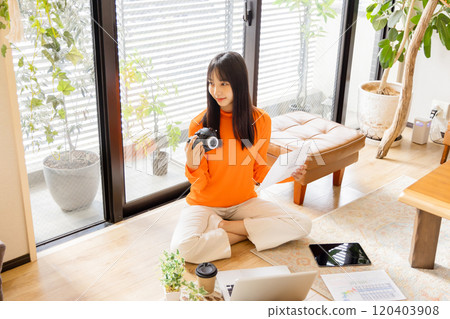 Young woman sitting on the floor and working 120403908