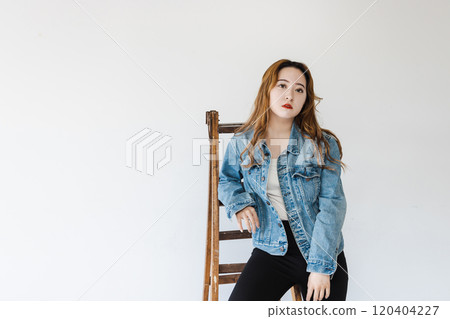 A quirky woman leaning on a stepladder brown hair flared leg pants A quirky woman leaning on a stepladder brown hair flared leg pants 120404227
