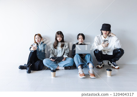 Generation Z men and women using smartphones, laptops, tablets (gadgets) Generation Z men and women using smartphones, laptops, tablets (gadgets) 120404317