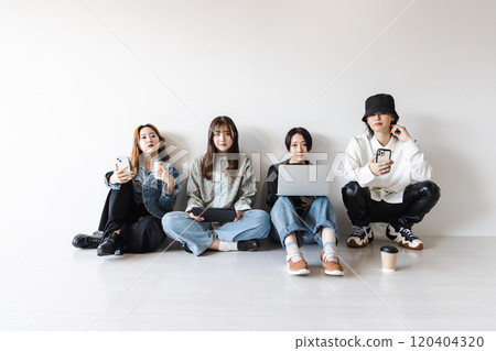 Generation Z men and women using smartphones, laptops, tablets (gadgets) Generation Z men and women using smartphones, laptops, tablets (gadgets) 120404320