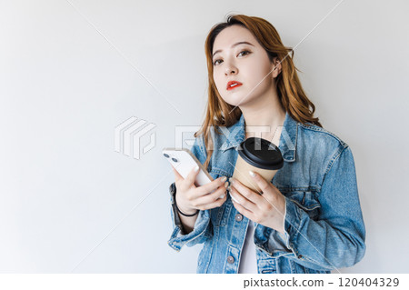 一個操作智能手機的年輕女子 120404329