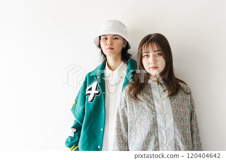 A stylish couple leaning against a white wall A stylish couple leaning against a white wall 120404642
