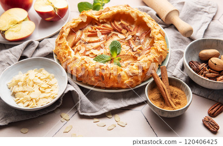 Delicious homemade apple galette decorated with almond flakes and fresh mint 120406425