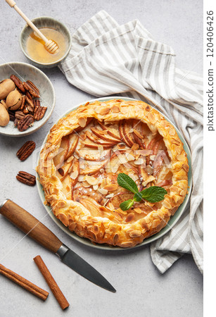 Delicious homemade apple galette decorated with almond flakes and fresh mint 120406426