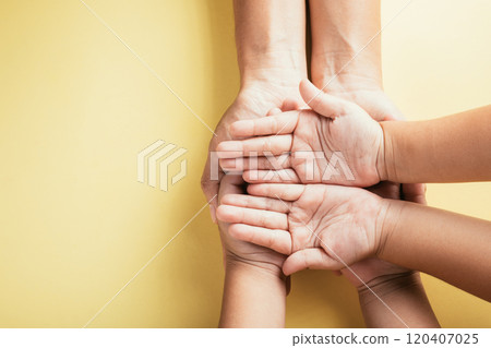 Emphasizing Family and Parents Day, Top view studio shot displays family hands stacked against an isolated background. Parents and children hold an empty space signifying support. 120407025