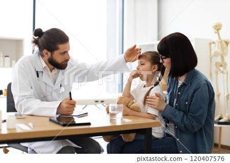 Caucasian doctor examines young girl during clinic visit 120407576