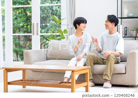 一對年輕夫婦在客廳裡放鬆 120408246