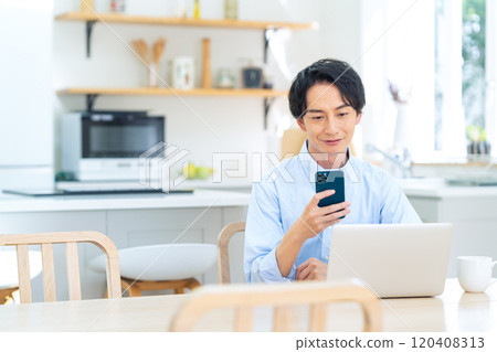 一個年輕人在客廳裡做遠程辦公 120408313