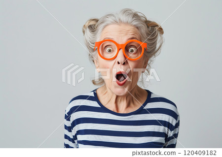 Joyful, very surprised 70 year old American woman with big amazed eyes and surprised mouth, with intense makeup, red lips, hair styling and red glasses. Live emotions. Idea for advertising. Banner 120409182